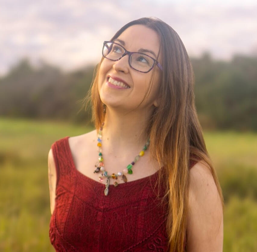 Krystal Linnea Human Design Self Krystal Linnea, Human Design guide, writer, healer, artist and mother of five - with a custom-printed Human Design Chart Report, surrounded by flowers in nature.