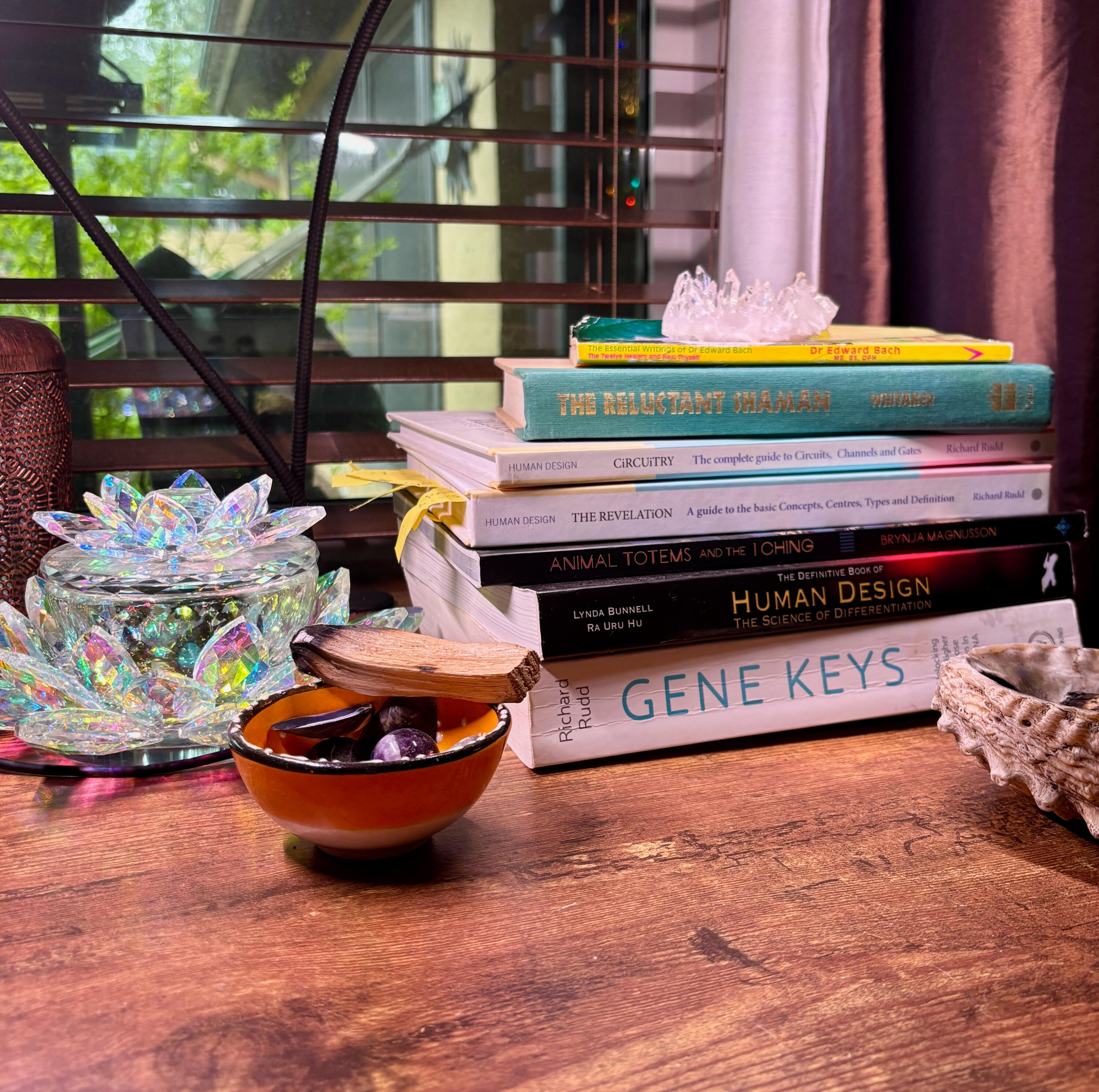 Krystal Linnea - Human Design Self - SelfAwakening Blog on Substack An image of crystals and books on Krystal Linnea's desk, including The Gene Keys, The Definitive Book of Human Design, The Revelation, Circuitry, The Reluctant Shaman, and The Essential Writings of Dr. Edward Bach + Heal Thyself.